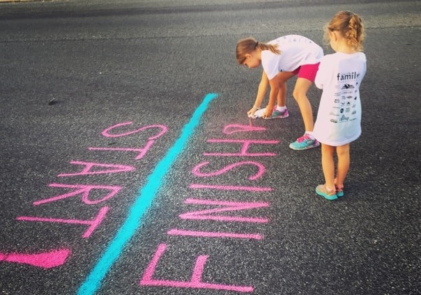 Deux petites filles dessinent une ligne de départ et d'arrivée